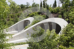 Attractive tunnels over highway in Tulsa Oklahoma near park and Arkansas River with many young trees supported as they grow and