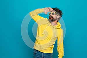 Attractive unshaved guy with sunglasses looking far away