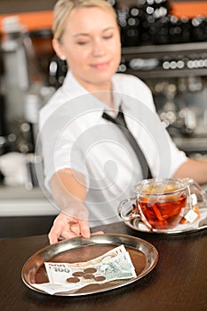 Attractive waitress taking tip in bar CZK