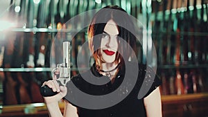 Attractive woman aims a gun.