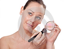 Attractive woman applying blusher