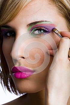 Attractive woman applying eyeshadow