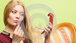 Attractive woman applying lipstick. Make up.