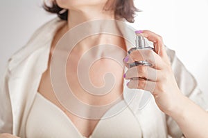 Attractive woman applying perfume