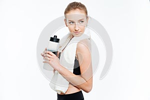 Attractive woman athlete holding bottle of water and white towel