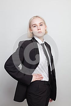 Attractive woman with blond bob hairstyle poses in a men\'s suit, fashion portrait