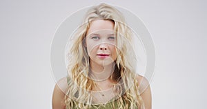 Attractive woman, blonde and face with curly hair standing isolated against a studio background. Portrait of caucasian