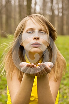 Attractive woman blowing kiss in nature