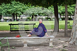 Attractive woman in a blue dress sitting in the park