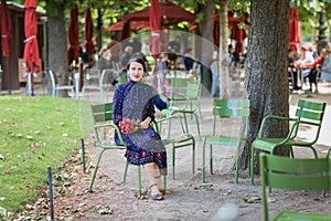 Attractive woman in a blue dress sitting in the park