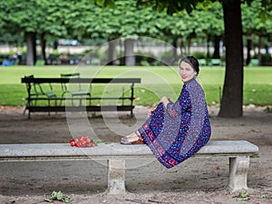 Attractive woman in a blue dress sitting in the park