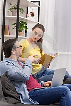 attractive woman with book in hands talking to boyfriend