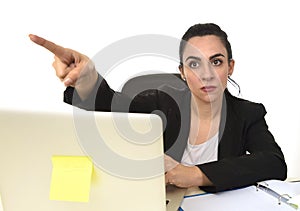 Attractive woman in business suit pointing with finger as if firing an employee