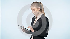An attractive woman in a business suit with tablet