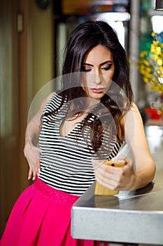 Attractive woman in cafe reading a text message from her phone