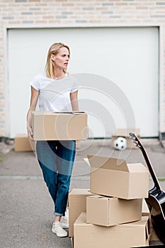 attractive woman with cardboard box moving into new photo