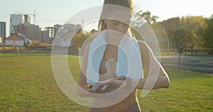 Attractive woman checking how much she running on a smart watch during the running in the city stadium.