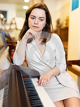 Attractive  woman chooses pianoforte in a record store