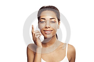 Attractive woman with clean skin applying moisturizing skincare cream, lotion or mask for skin lifting and anti-aging detoxifying