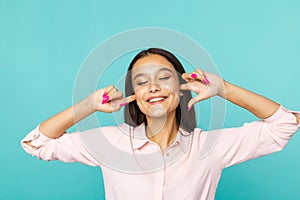 Attractive woman closing her ears by fingers and smiling isolated.