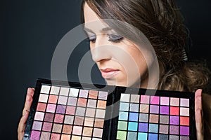 Attractive woman with colorful palette for fashion makeup