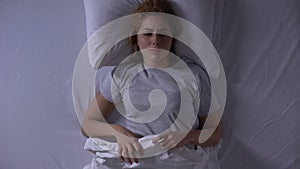 Attractive woman crying lying in her bed at night, female weakness and fragility