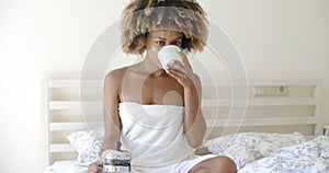 Attractive Woman With A Cup Of Coffee On The Bed