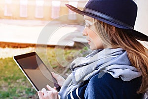 Attractive woman with digital tablet in hand talking on mobile phone with bpyfriend before a meeting with it. Young girl