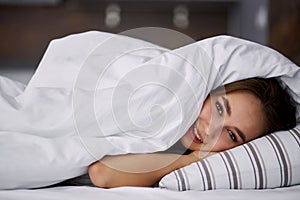 Attractive woman doesn`t want to get out of bed in the morning