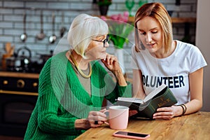 Attractive woman doing Bible reading with appealing aged female