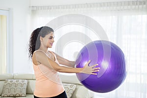 Attractive woman doing exercise with pilates ball