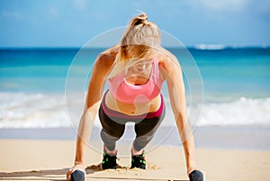 Attractive woman doing push ups outside.