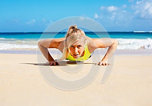 Attractive woman doing push ups outside.