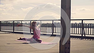 Attractive woman doing yoga exercises outdoors