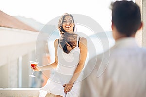 Attractive woman drinking cocktail and enjoying her summer vacation.Drinking refreshing drink and smiling to a man