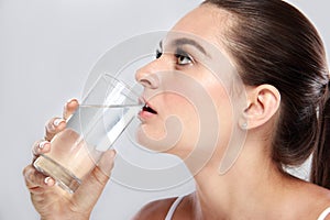 Attractive woman drinking a glass of mineral water