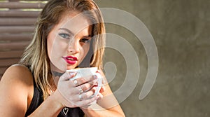 Attractive woman drinking a hot beverage