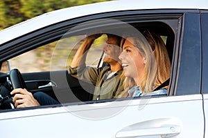 Attractive woman driving car with boyfriend next to her