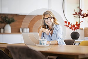 Attractive woman with earphone using her laptop at home