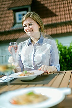 Attractive woman eating breakfast on her home balcony