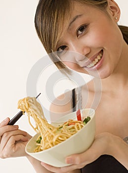 Attractive woman eating noodles