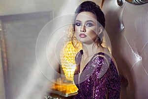 Attractive woman in evening purple shiny dress , hairstyle and h