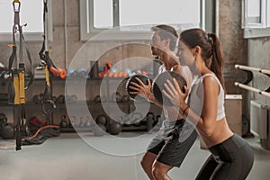 Attractive woman exercising with instructor in the gym
