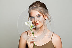 Attractive woman face close-up. Blonde model with fresh clear skin and healthy silky hair on white background