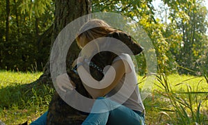 Attractive woman gently hugging her nice dog