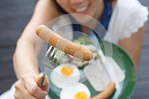 Attractive woman giving a sausage