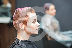 Attractive woman with glamour wet short pink hair at beauty salon