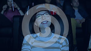 Attractive woman in glasses laughing having fun in cinema with group of people