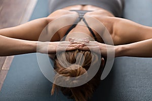 Woman practicing yoga, doing neck strengthening exercises on mat photo