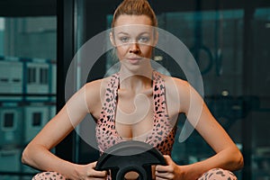 Attractive woman and handsome muscular man are training in light modern gym. Young caucasian white woman doing workout